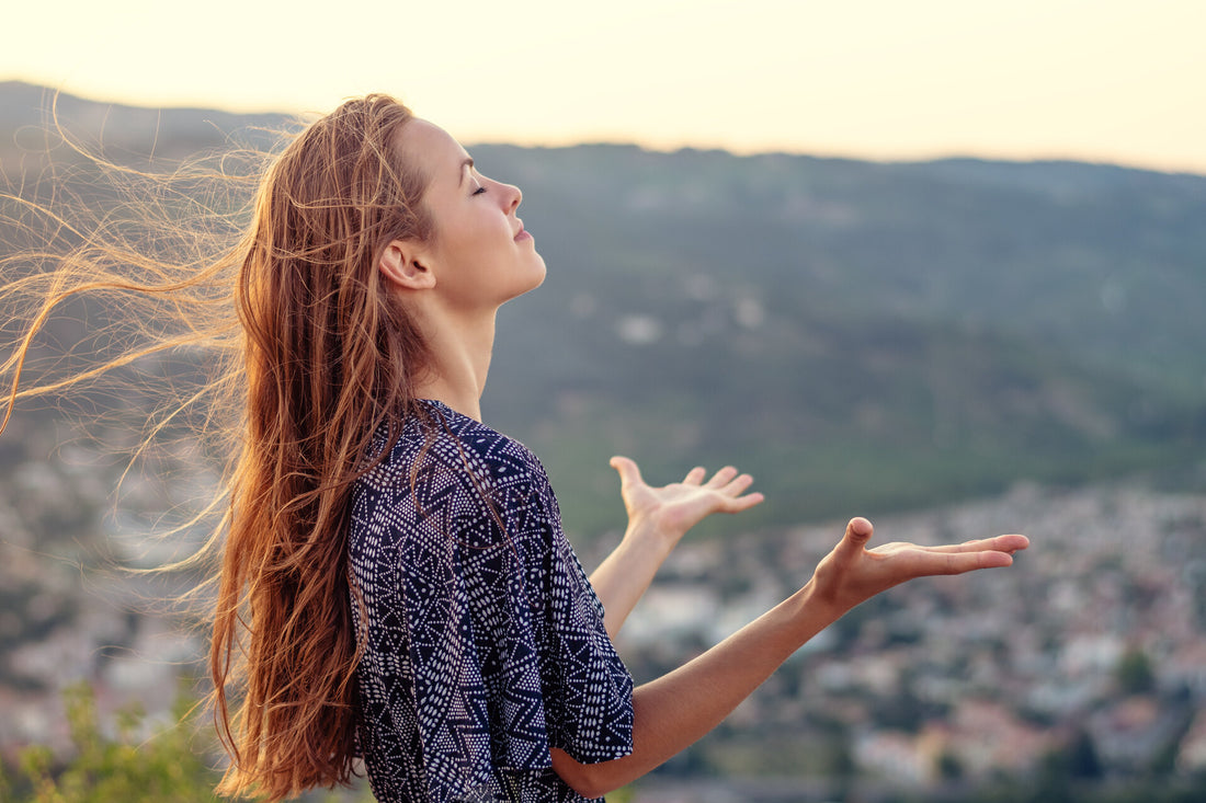 Woman outside with palm facing up; Embrace life